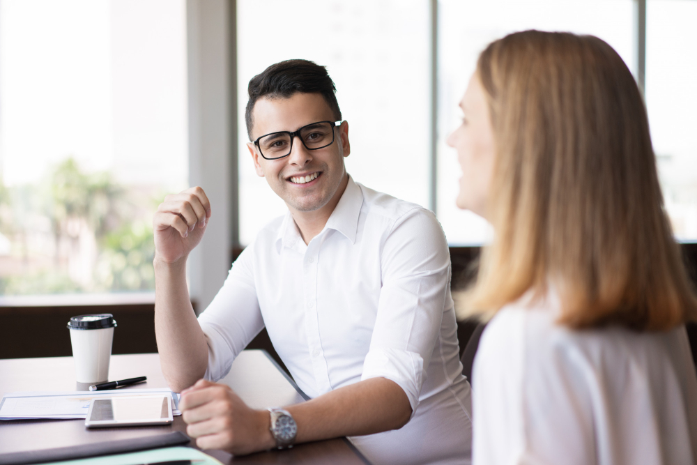 Two business professionals discussing a project during a meeting in a modern office workspace